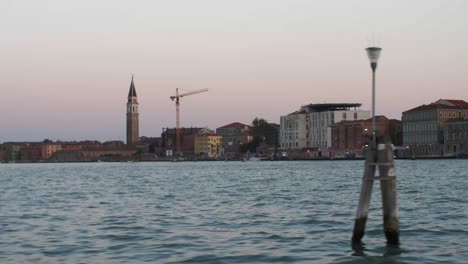 Tower-and-multi-story-houses-of-Venice-city,-moving-boat-view