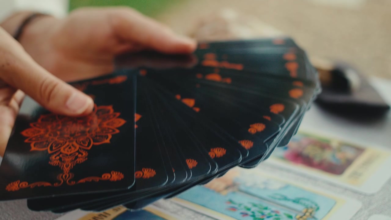 Person Spreading Tarot Cards for a Reading