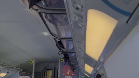 modern train interior with overhead lights and bags stored in luggage racks