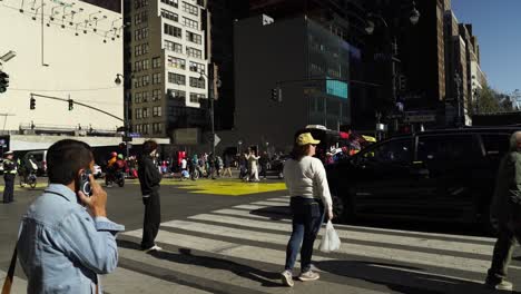 as the sun shines brightly, crowds of people fill the streets near madison square garden, united in their support for trump