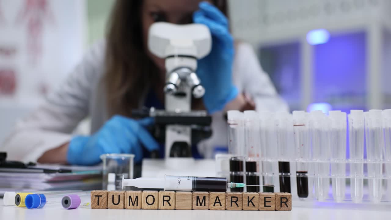 Laboratory worker examines blood sample under microscope