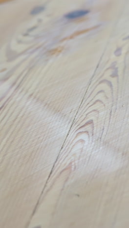 detailed vertical shot captures the transition on pine wood floor as sanding removes the old finish, revealing natural grain and texture, highlighting restoration process and material details