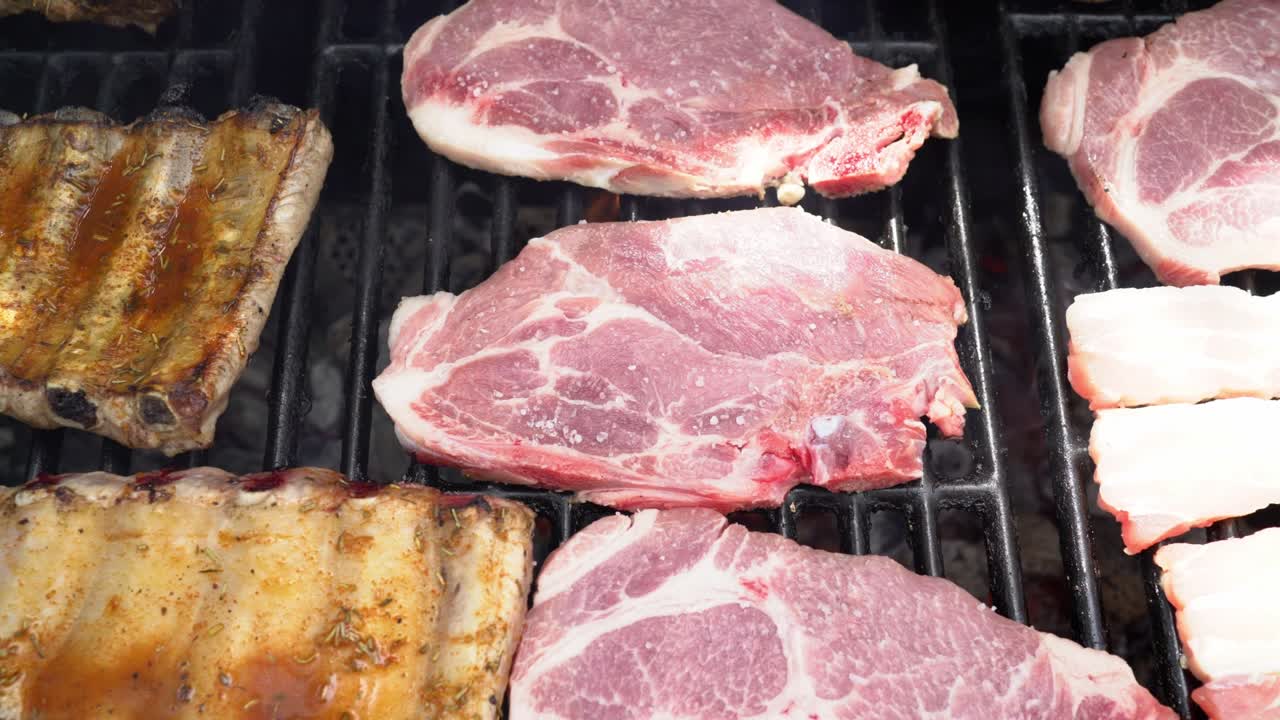 el chef puso sal para cocinar costillas de cerdo en la parrilla de la barbacoa. cerdo a la parrillas cocinado en la barbacoa