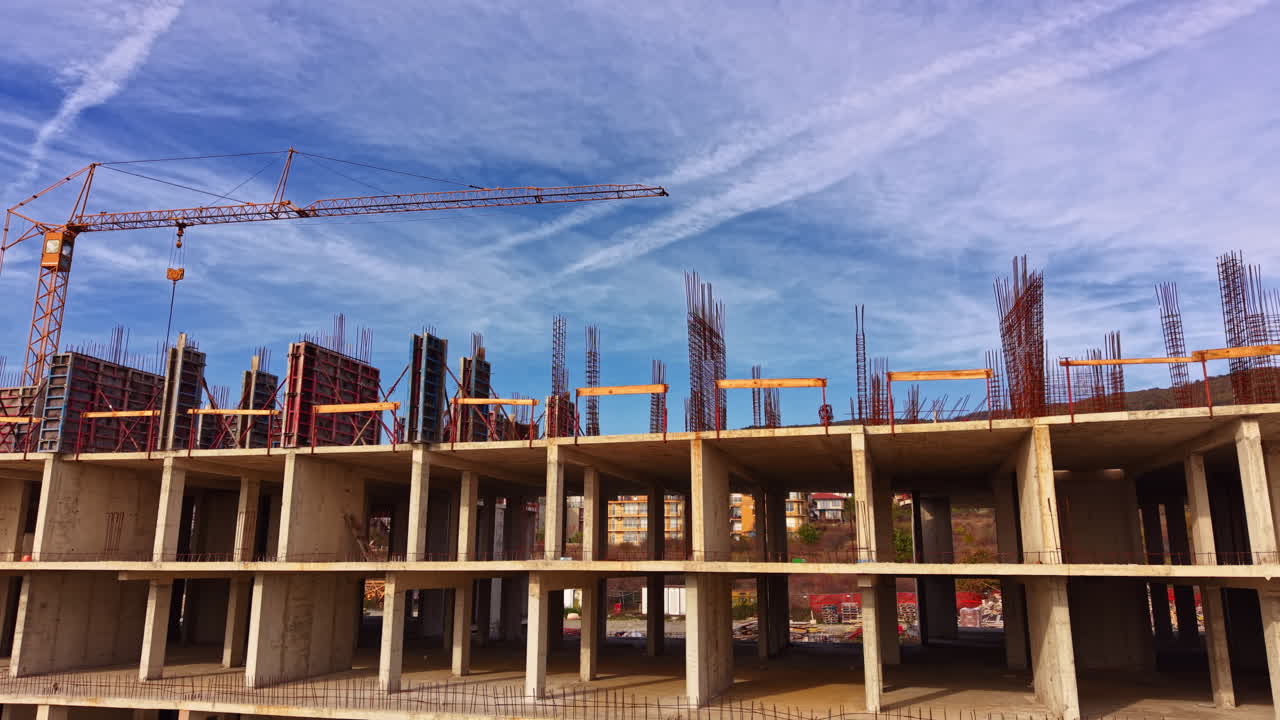 Construction site bustling with activity under a bright blue sky showcasing rising structures and cranes at work during the golden hour