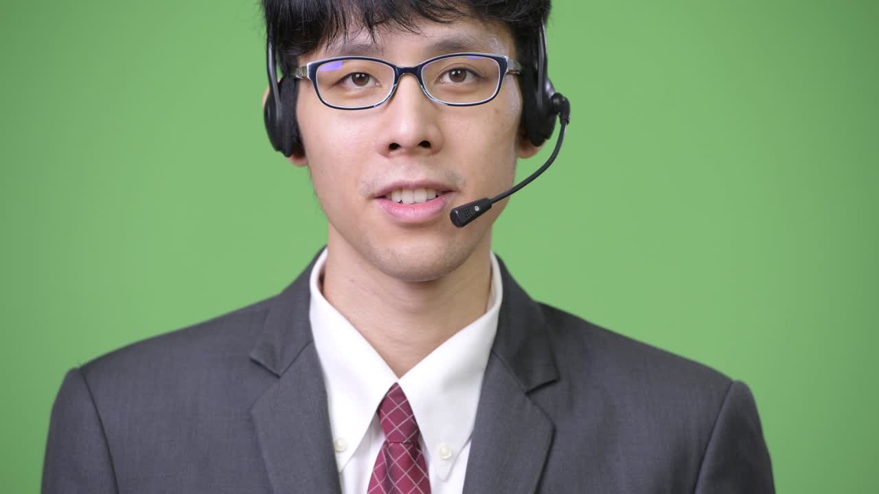 웃는 젊은 아시아 사업가와 콜 센터 대리인으로 일하는