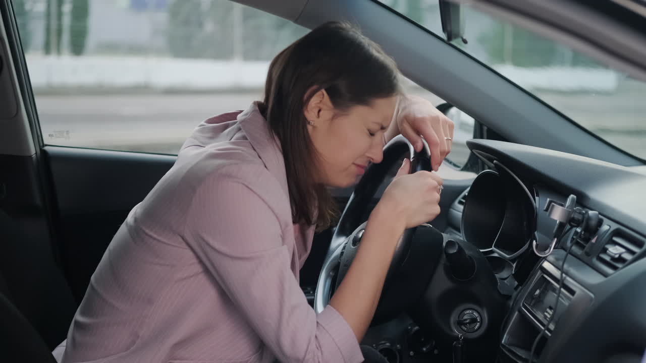 자동차에 있는 여성이 고통이나 피곤함을 나타니다.