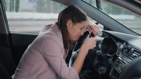 mujer en el coche mostrando angustia o cansancio