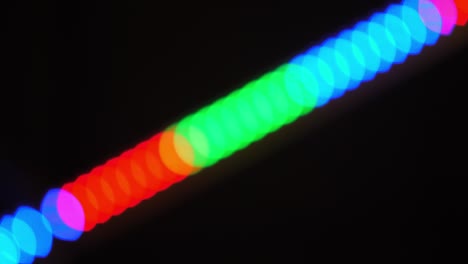 bokeh shot of defocused blurred christmas tree light that is blinking on black