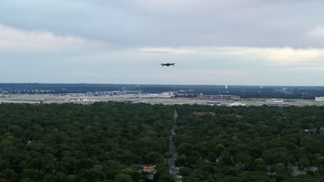 a drone hovers momentarily before zooming away towards an airport