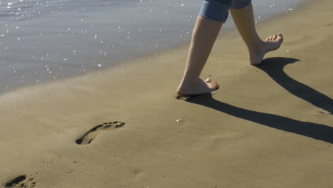 female legs walk on a beach