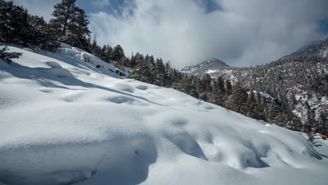 zeitraffer einer ruhigen weißen winterlandschaft, schneebedeckte berghügel an einem sonnigen tag