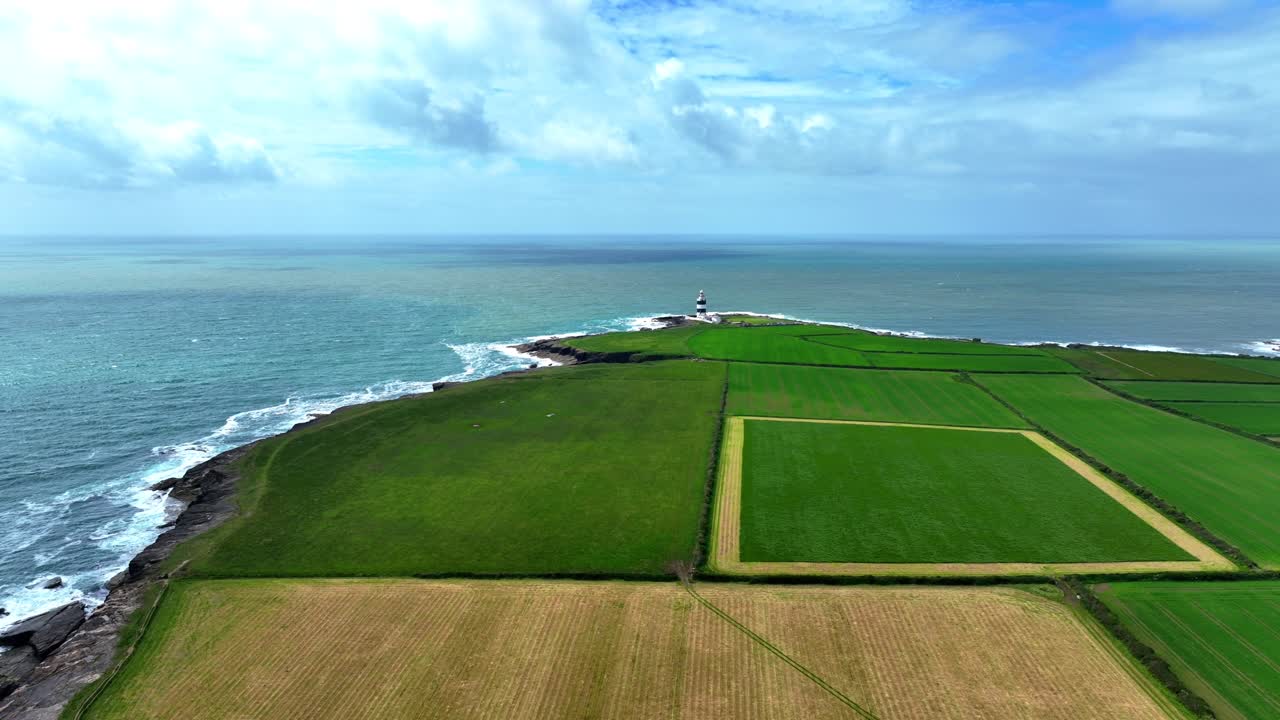 웨크스포드 (wexford) - 허크 반도 (hook peninsula) 의 비옥한 초록색 농경지, 배경에는 허크 등대 (hook lighthouse) 와 푸른 바다 (blue sea) 가 있다.