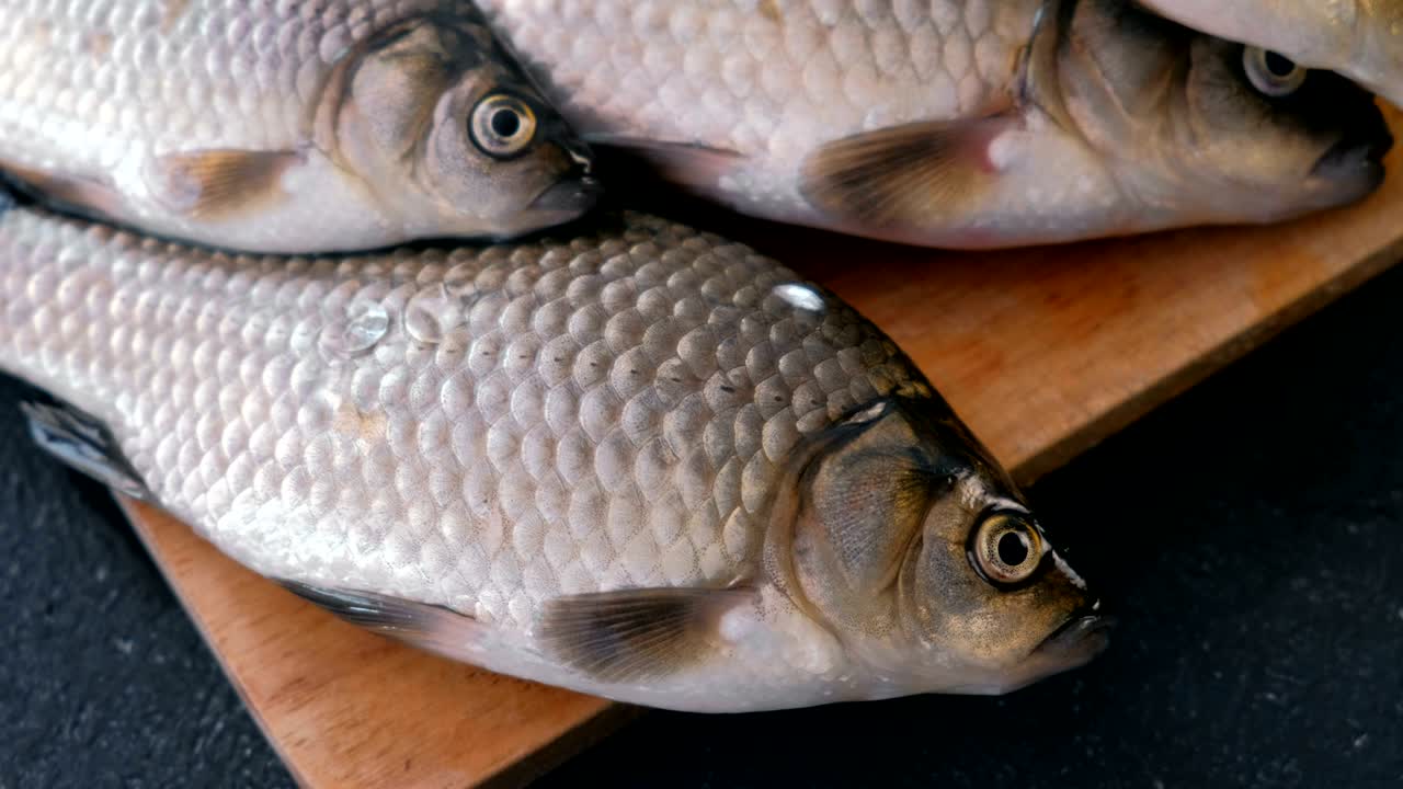 pescado de cocina. carpas pequeñas frescas en la mesa en una tabla de madera de primer plano.