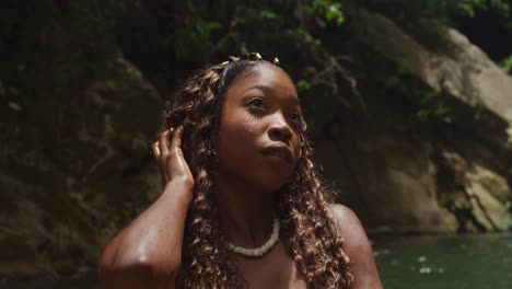 two girls in bikinis are enchanted by a tropical waterfall and river in the caribbean.