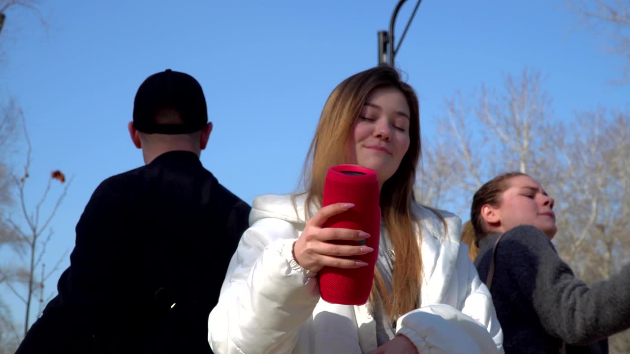 젊은 소녀 들 과 남자 들 이 함께 공원 에서 음악 의 리 에 따라 춤 을 춘다