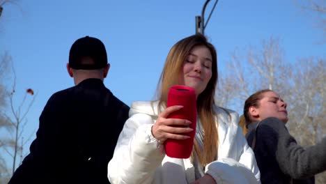 chicas jóvenes y chicos bailando al ritmo de la música en el parque juntos