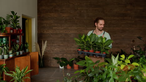 hombre llevando plantas en una tienda de plantas