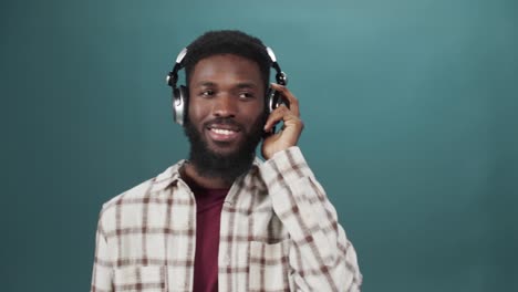 an african young man in a white shirt is listening to music and dancing