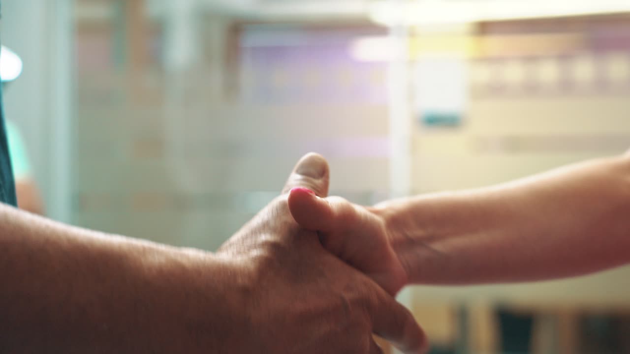 Close-up view of a handshake between two people for a business purpose in an indoor environment