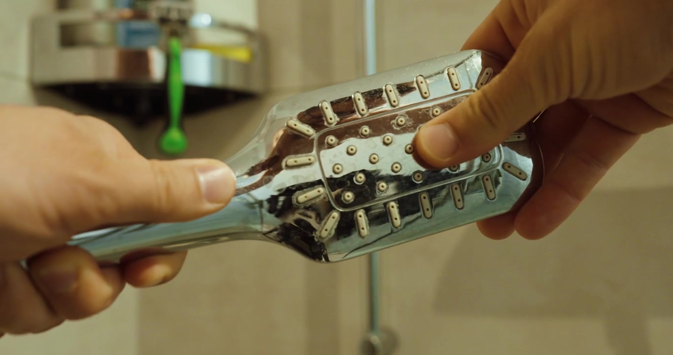 Video stock in primo piano di un soffione doccia utilizzato per concetti legati a germi, accumulo di batteri, rischi igienici, contaminazione dell'acqua, pulizia, manutenzione del bagno e consapevolezza della salute domestica.