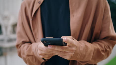 Man-fingers-texting-smartphone-park-vertically-closeup.-Unknown-guy-typing-phone