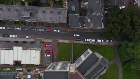 Vista-Aérea-De-Pájaros-Vista-De-Seguimiento-De-Arriba-Hacia-Abajo-Del-Coche-Que-Da-Paso-Al-Tráfico-Que-Se-Aproxima-En-Una-Calle-Angosta-De-La-Ciudad.-Londres,-Reino-Unido