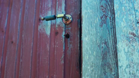 Hand-Einer-Person,-Die-Einen-Vintage-Schlüssel-Eines-Holzchalets-öffnet