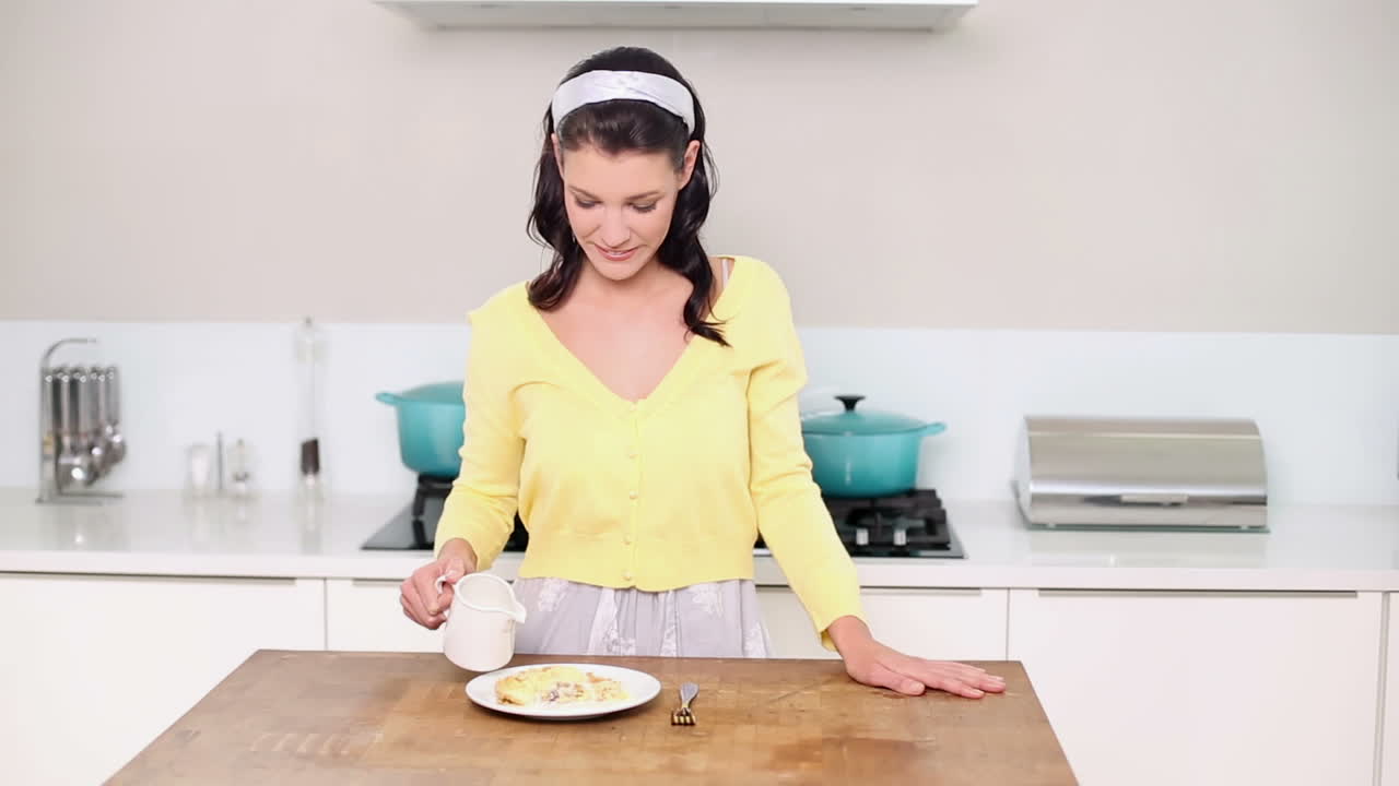 hermosa morena vertiendo crema en un postre