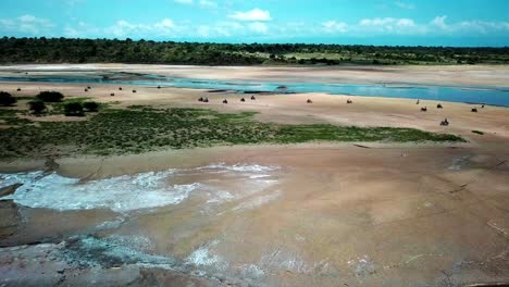 jinetes en motocicletas alrededor del lago magadi en kenia - toma aérea de drones