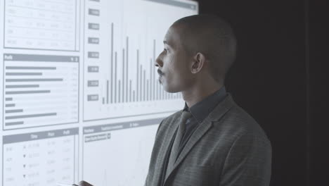 Pensive black professional investor analyzing statistics