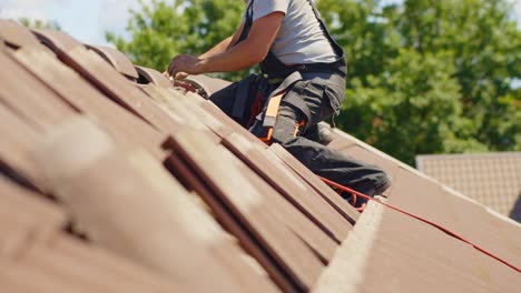 repairman, fixing the tiles on rooftop of hut