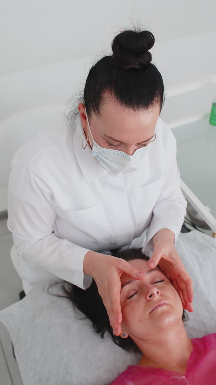 terapeuta de cosmetología haciendo mujer relajante spa masaje facial con las manos en el salón de desintoxicación y curación