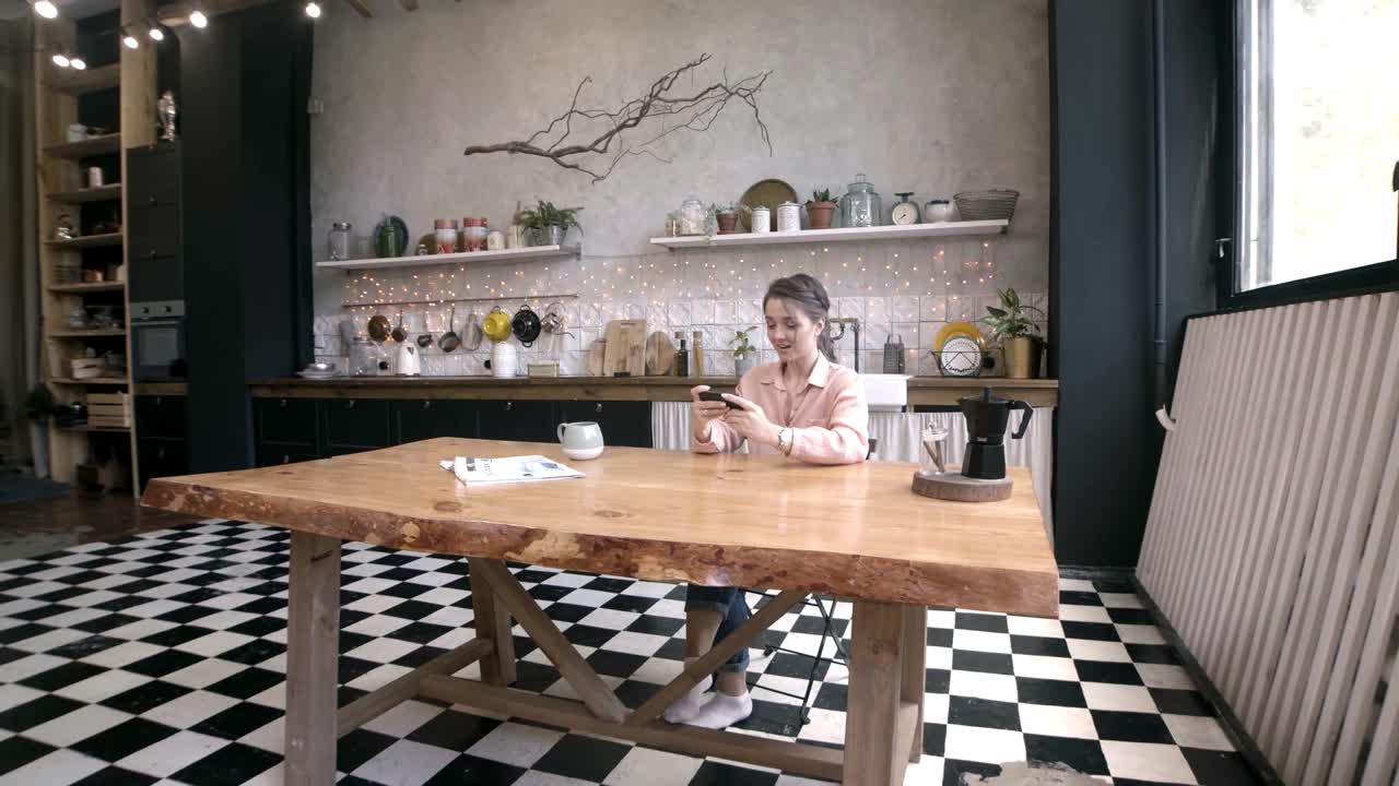 mujer usando el teléfono en una cocina moderna