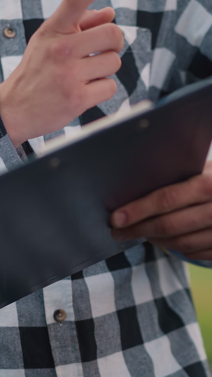 primer plano del entrenador sosteniendo la pelota de voleibol bajo el brazo y el libro de récords en la mano con un fondo borroso de una cancha de voleobol, el entrenador está listo para las instrucciones, enfocado y profesional