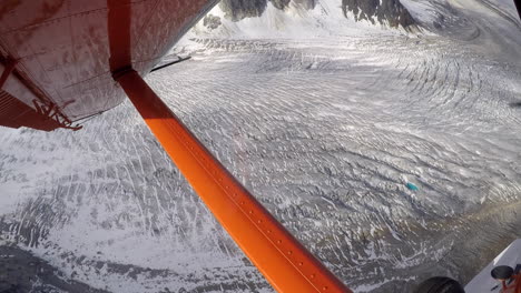 flying in a red airplane over alaska's beautiful glaciers