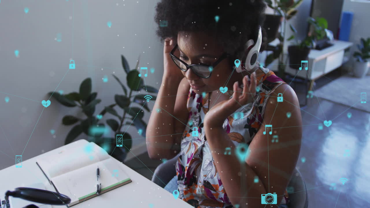 Woman adjusting over-ear headphones at modern tech workspace desk, showing floating data icons