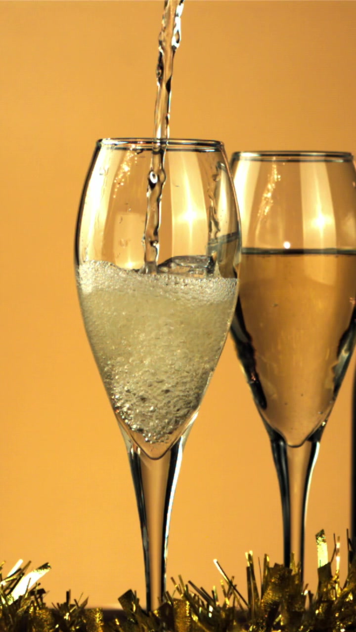 Champagne versato al rallentatore in un flute con decorazioni dorate.