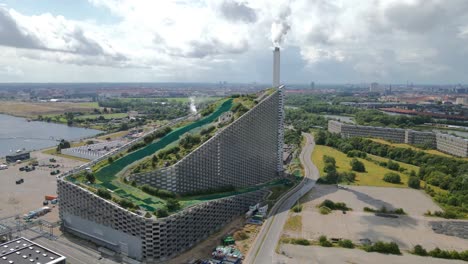 aerial view highlighting copenhill, or amager bakke, a copenhagen waste-to-energy plant merging sustainability with leisure activities like skiing, hiking, and climbing establishing drone shot