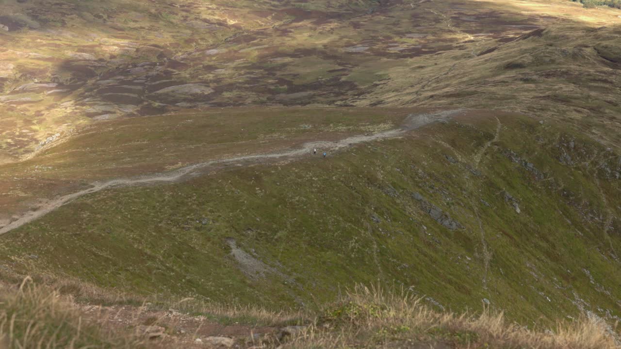 Static shot of hikers descending Ben Vorlich after summiting in summer