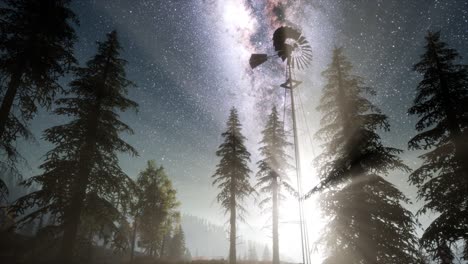 molino de viento retro en el bosque de montaña con estrellas. hiperlapso