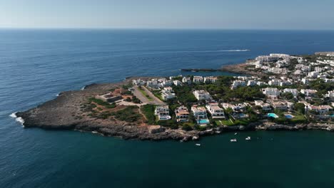 vista aérea con drone viendo la ciudad de cala d'or con casas blancas, acantilados y el mar mediterráneo y la fortaleza de es forti