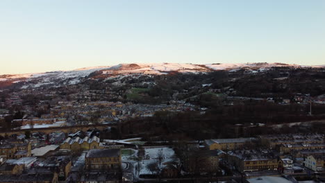 Schwenk-Nach-Oben-Von-Schneebedeckten-Hügeln,-Die-Zur-Goldenen-Stunde-Natürlich-Leuchten