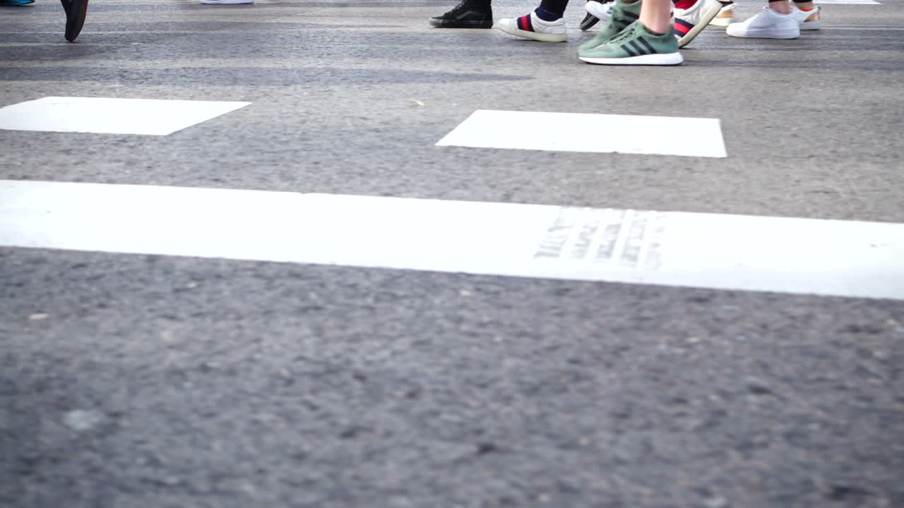 People cross the road on the crosswalk. Slow motion. Pedestrians cross the road. Slow motion