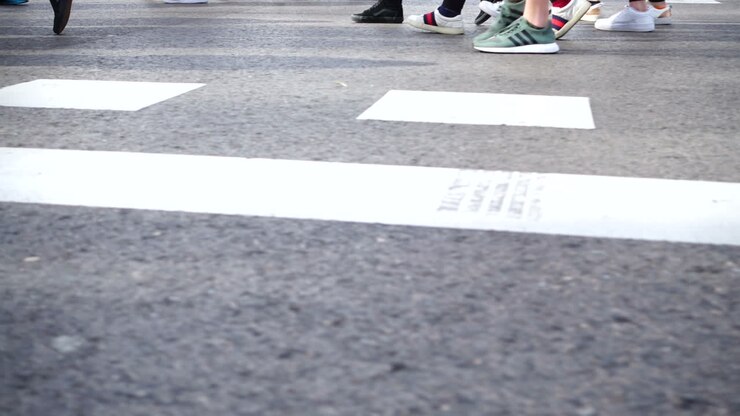 People cross the road on the crosswalk. Slow motion. Pedestrians cross the road. Slow motion