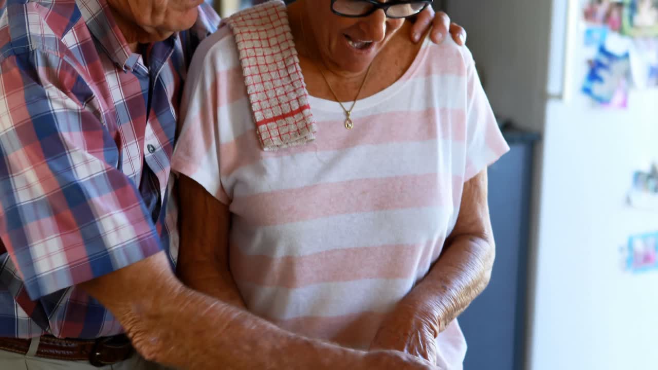 pareja de ancianos cortando verduras en la cocina 4k