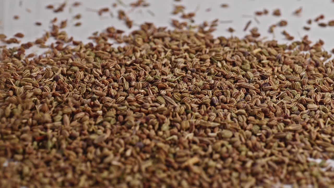 Ajwain falling on white surface and bouncing, 4k, stable shot