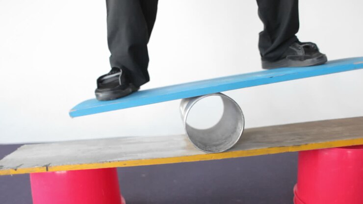 A man balances on a board and a tube