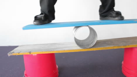 a man balances on a board and a tube