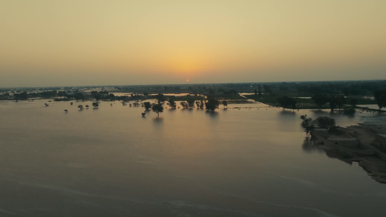Vista aerea al tramonto su un villaggio allagato e terreni agricoli a Jalalpur Pirwala, Punjab, Pakistan