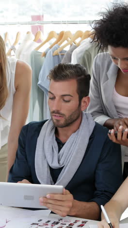 equipo de diseño de moda ocupado trabajando juntos en la mesa